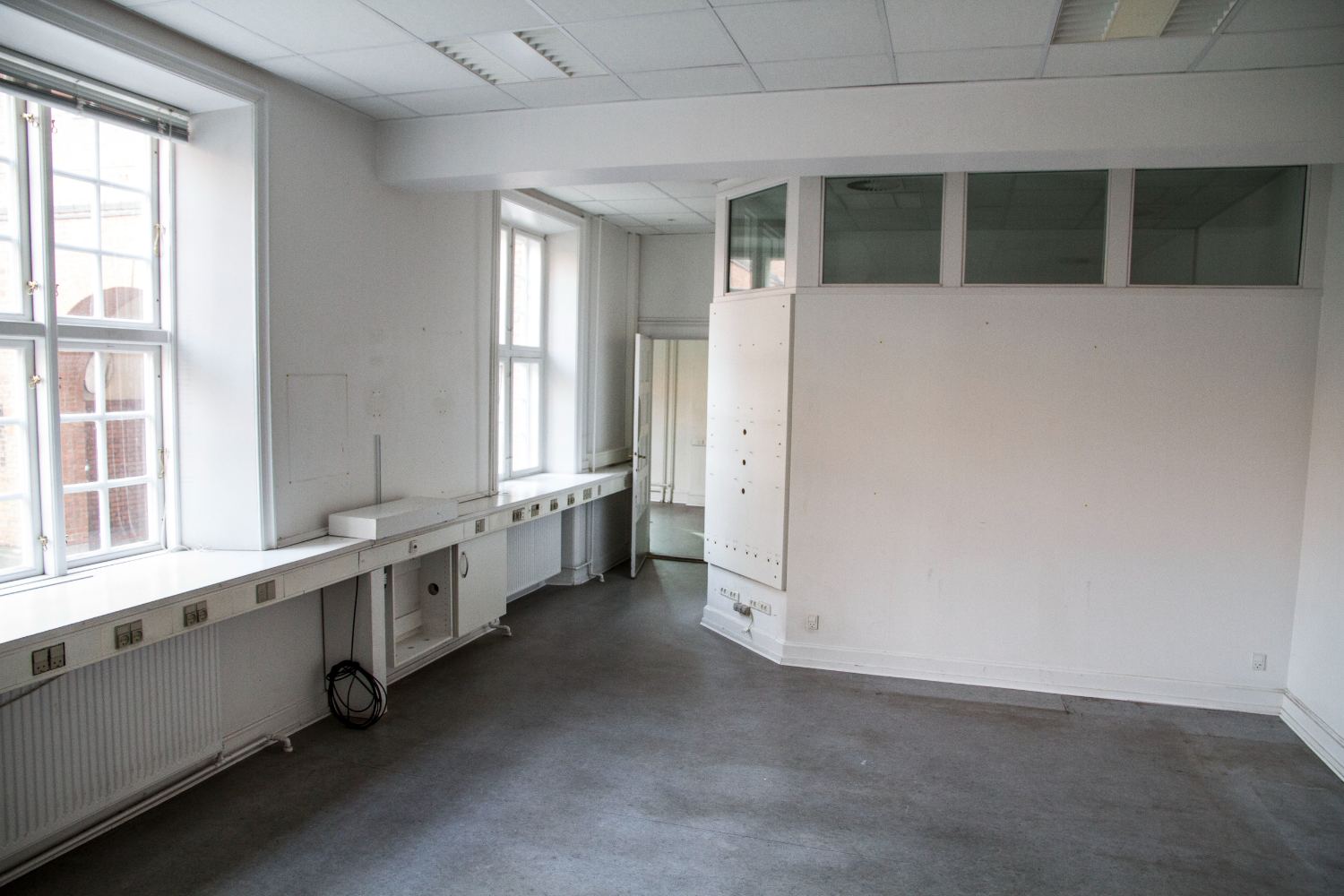 Empty office with window desks and a glazed partition